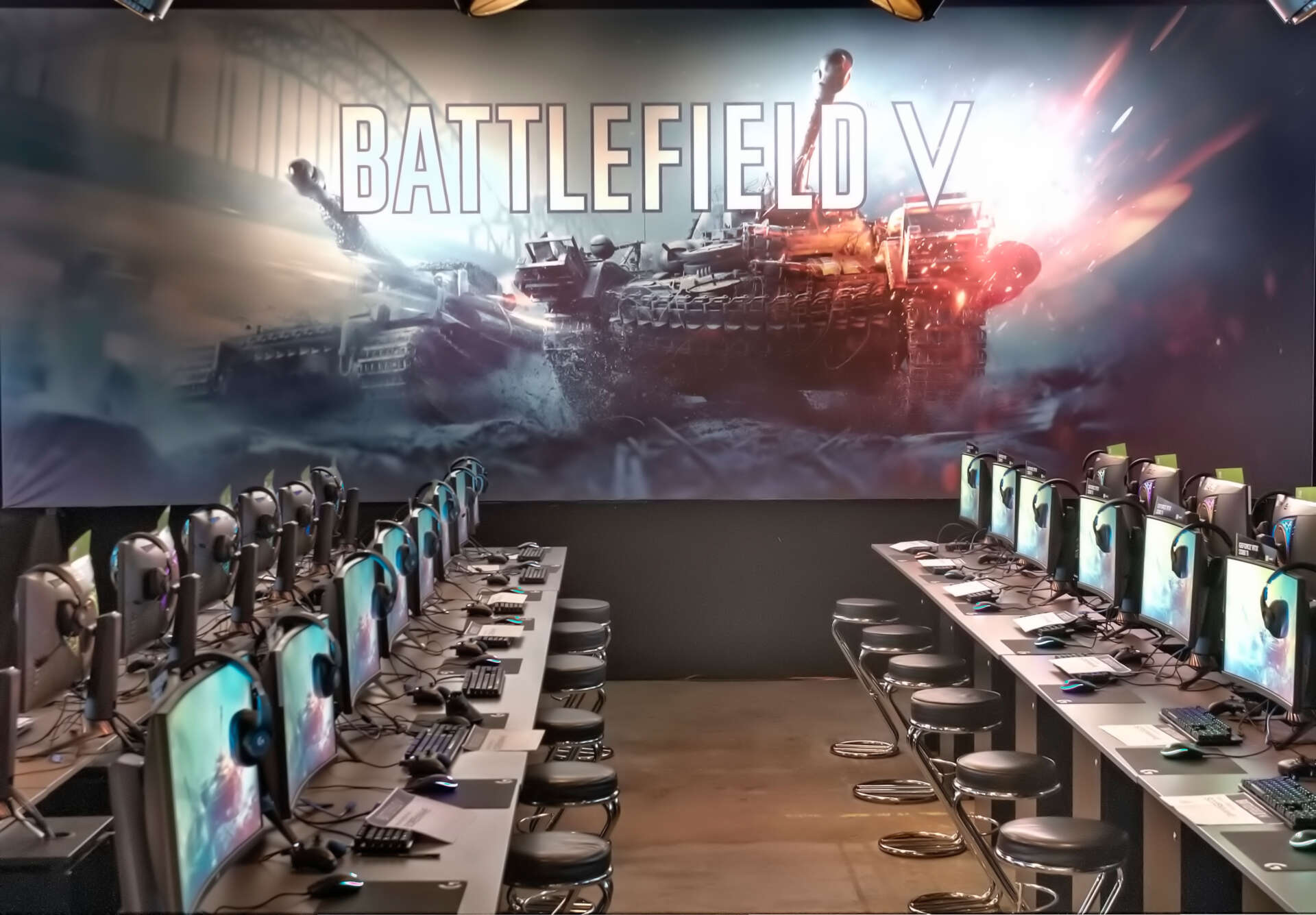 Hinter aufgereihten Gaming-PCs steht eine große Brandingwand, auf der zwei Panzer und ein Battlefield V Schriftzug zu sehen sind
