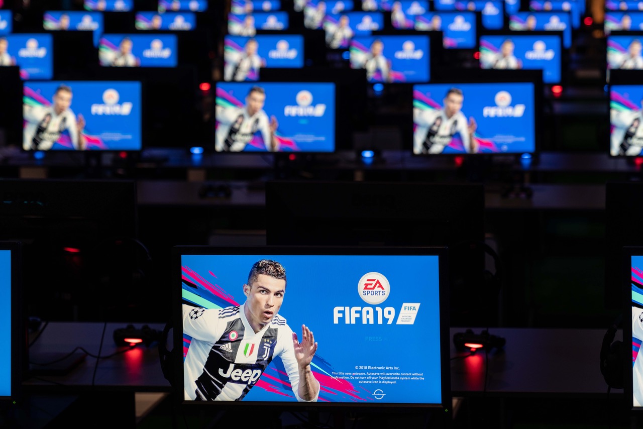 Ein Monitor mit Fifa 19 Startbild im Vordergrund und mehreren Reihen mit Bildschirmen im Hintergrund