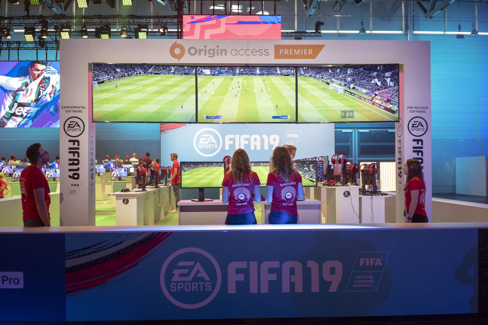 Promotoren stehen im Fifa-19-Bereich auf dem EA-Messestand auf der gamescom 2018 vor einem Screen, der aus drei Bildschirmen besteht