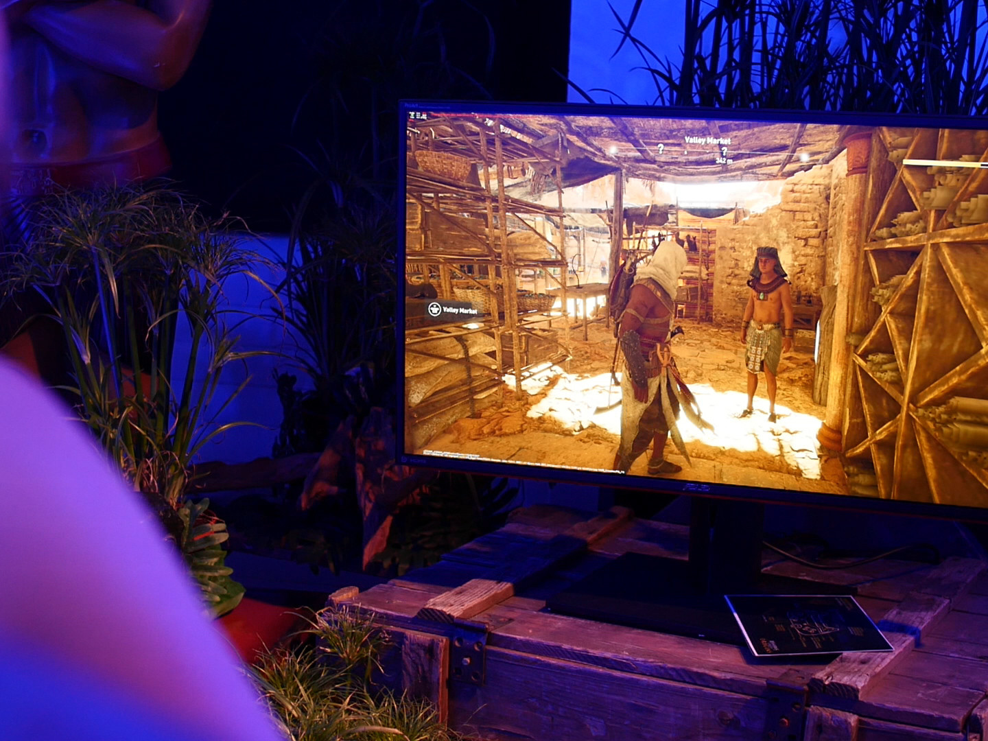 Auf einem Bildschirm, der auf einer antiken Holztruhe steht, laeuft ein Computerspiel